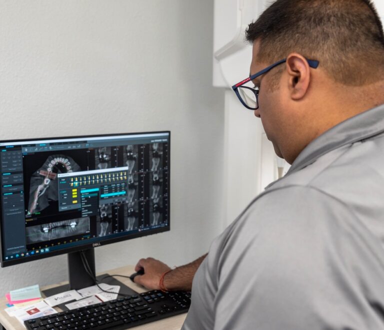 Dr. Rupesh Singla working on a dental implant using a CT 3D imaging system - guided dental implants technology in Duncanville, TX