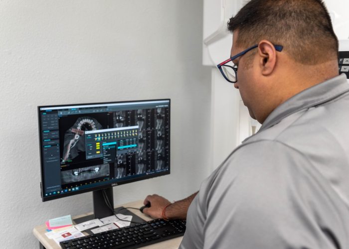 Dr. Rupesh Singla working on a dental implant using a CT 3D imaging system - guided dental implants technology in Duncanville, TX